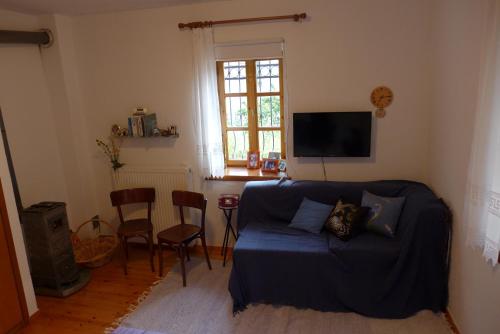 a living room with a couch and a table at Πέτρινο παραδοσιακό σπίτι "Χιονάτη" in Nimfaíon