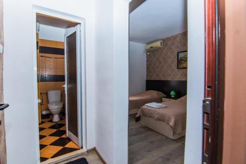 a small room with a bed and a mirror at Vida Family Hotel in Vidin
