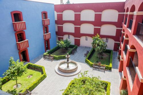 an apartment building with a fountain in the courtyard at Hotel Real de Naturales in Cholula