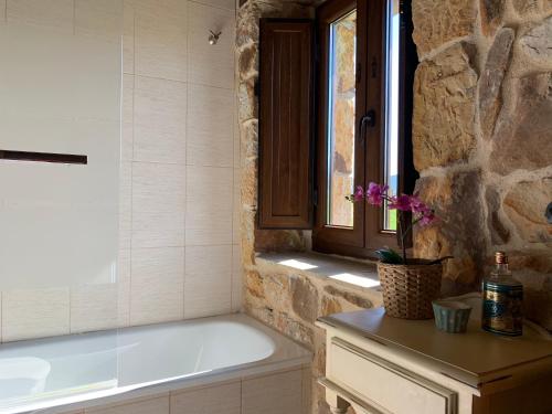 ein Bad mit einer Badewanne und einem Fenster in der Unterkunft El manantial in Liérganes
