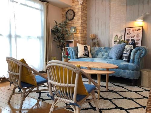 uma sala de estar com um sofá azul e uma mesa em Scarl Matsunawa / Vacation STAY 49770 em Takamatsu