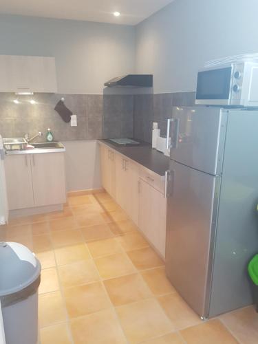 une cuisine avec un réfrigérateur en acier inoxydable et un évier dans l'établissement Les Belles Nuits, à Le Bousquet-dʼOrb