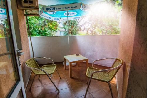 a table and two chairs and a table and an umbrella at Vida Family Hotel in Vidin