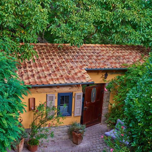 une petite maison jaune avec un toit rouge dans l'établissement Biggi‘s Garten-Finca, à Flonheim