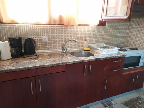 a kitchen counter with a sink and a stove at Apartment Victoria in Agios Georgios