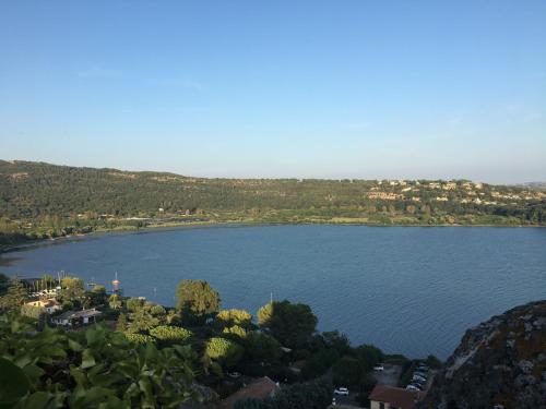 a view of a lake with trees and houses at APPARTAMENTO OSIDE HOUSE alloggio turistico in Trevignano Romano