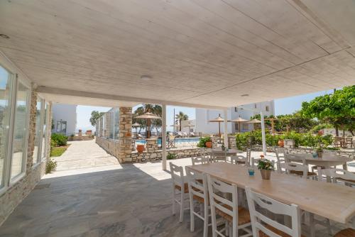 a patio with tables and chairs and a pool at Christiana Hotel in Ambelas