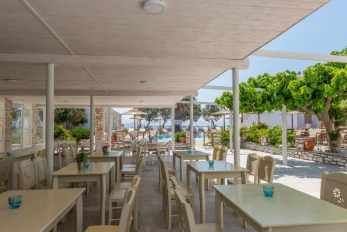 a restaurant with tables and chairs with a view at Christiana Hotel in Ambelas