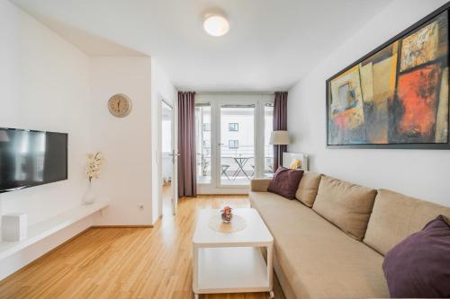 ein Wohnzimmer mit einem Sofa und einem Tisch in der Unterkunft Apart SKY Residence Hauptbahnhof with Balcony in Wien