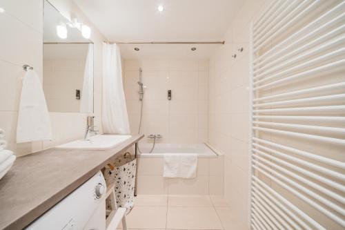 a white bathroom with a sink and a shower at Apart SKY Residence Hauptbahnhof with Balcony in Vienna