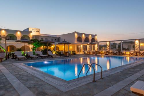 - une piscine avec des tables et des chaises la nuit dans l'établissement Christiana Hotel, à Ambelas