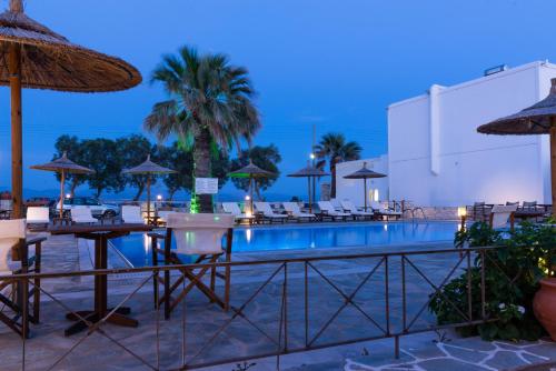 a pool at a resort with tables and umbrellas at Christiana Hotel in Ambelas
