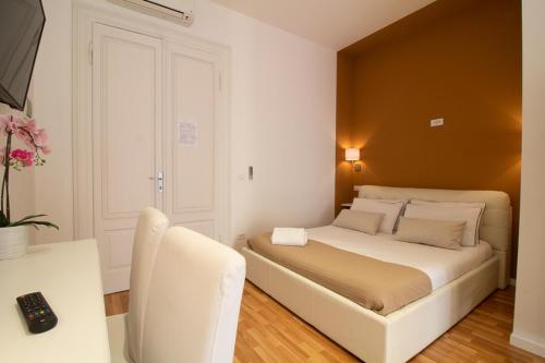 a bedroom with a white bed and a white chair at Maison Amelie in Trieste