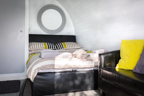 ein kleines Schlafzimmer mit einem Bett und einem Fenster in der Unterkunft Buttles Glamping Pod in Saundersfoot