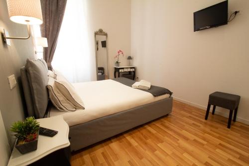 a bedroom with a bed and a television on the wall at Maison Amelie in Trieste