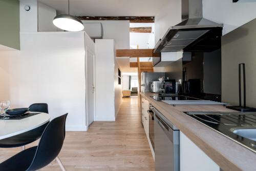 une cuisine avec un comptoir, des chaises et une table dans l'établissement La suite numéro 1, à Carcassonne