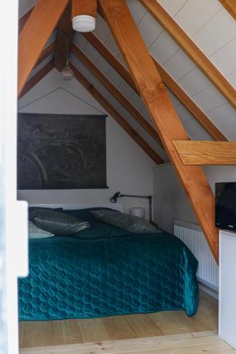 Un dormitorio con una cama verde en un ático en Mini appartement De Fabriek en Nijmegen