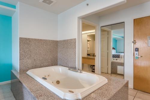 a large bath tub in a room with a bedroom at Pacifica Beach Hotel in Pacifica