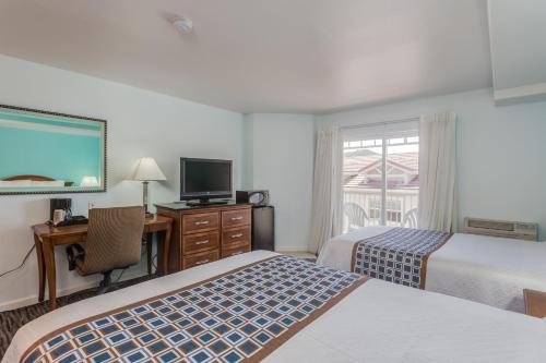 a hotel room with two beds and a flat screen tv at Pacifica Beach Hotel in Pacifica