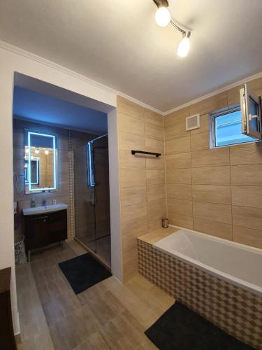 a bathroom with a large tub and a sink at Casa Anton Buzău in Buzău