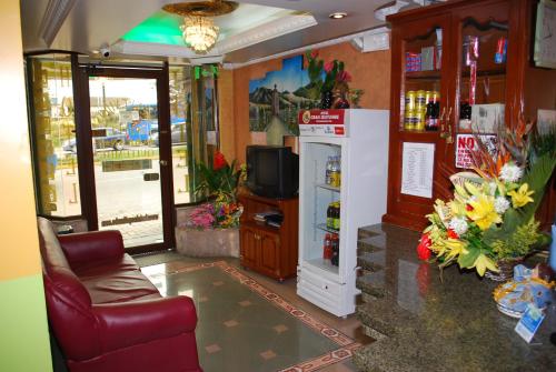 a living room with a refrigerator and a television at Hotel Gran Quitumbe in Quito