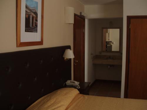 a hotel room with a bed and a mirror at Montecassino in Capilla del Monte