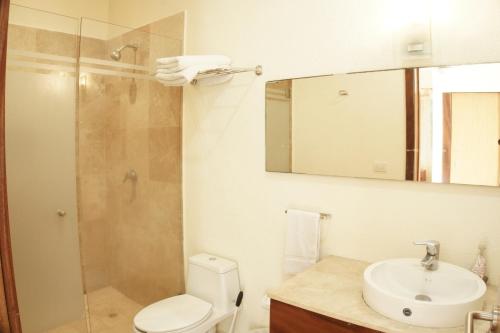 y baño con aseo, lavabo y ducha. en Hermoso Apartamento con Piscina/RoofGarden/Ac/ en Sayulita., en Sayulita