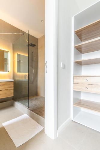 a bathroom with a shower and a glass door at CAPLAGE - BEACHFRONT GROUND FLOOR APARTMENT in TAMARIN in Tamarin