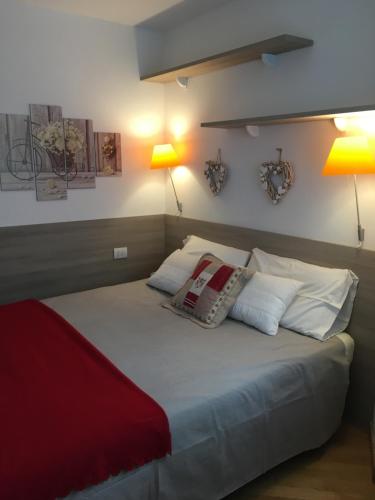 una camera da letto con un letto con cuscini e due lampade di Appartamento Alla Fonte a Madesimo