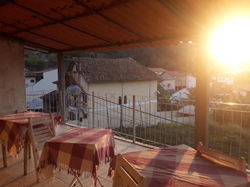 a balcony with tables and a view of a house at Pousada Preludio in Conservatória