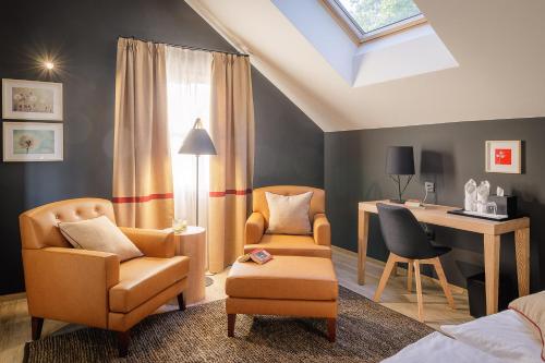 a bedroom with a desk and two chairs and a table at Boutique Hotel Sunrose 7 - Gourmet & SPA in Bohinj
