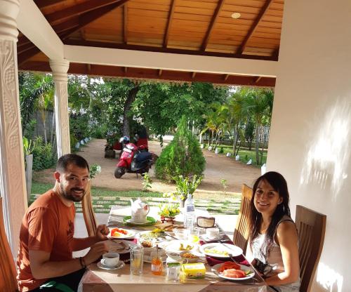 a man and woman sitting at a table with food at Tamarind Tamarind Resort, Tourist Board Approved in Habarana