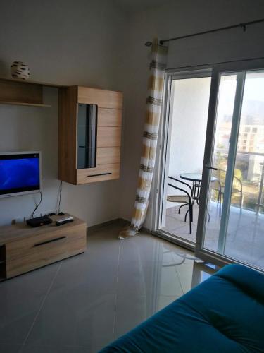 a living room with a tv and a sliding glass door at Vi apartment 1lin of the sea in Bar