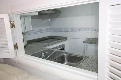 cocina con fregadero y espejo en Apartamento acogedor en lugar inmejorable, en Sanlúcar de Barrameda