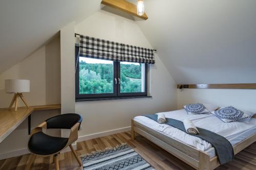a bedroom with a bed and a window at DOMKI TU I TERAZ in Szczawnica