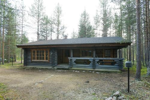 a log cabin in the middle of a forest at Joutsen Holiday Home in Luosto