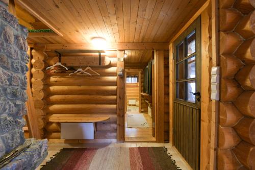 a log cabin hallway with a table and a window at Joutsen Holiday Home in Luosto