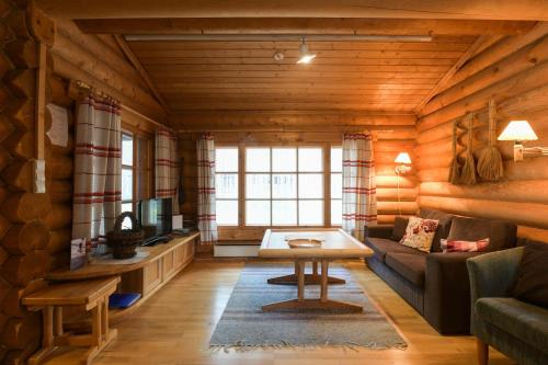 a living room with a couch and a table at Joutsen Holiday Home in Luosto