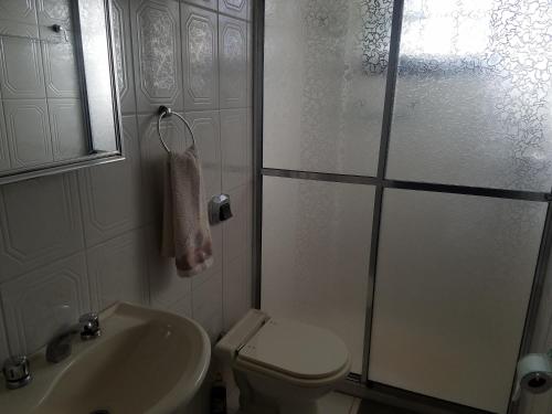 y baño con aseo, lavabo y ducha. en Apartamento na Serra, en Canela