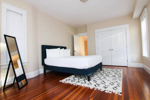 a bedroom with a large bed and a mirror at Luxury 3 Bedroom, 20 min to Boston, 15min Encore in Malden
