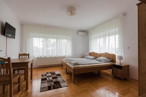 1 dormitorio con cama, mesa y escritorio en Airport Jazmin Guesthouse en Vecsés