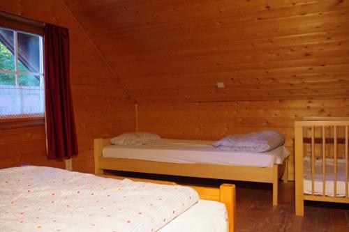 una camera con 2 letti in una baita di tronchi di Au Beolin a Houffalize