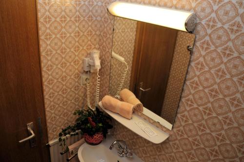 een badkamer met een wastafel en een telefoon in een spiegel bij Pension Belvedere in Galtür