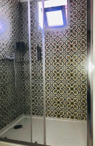 ein Badezimmer mit Dusche und gefliester Wand in der Unterkunft Casa do Nini in Amarante