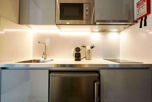 a kitchen with a sink and a microwave at Almar Apartments in Póvoa de Varzim