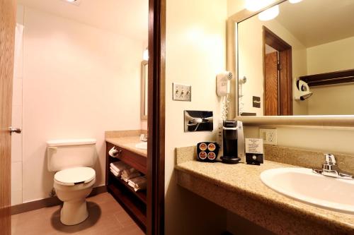 W łazience znajduje się umywalka, toaleta i lustro. w obiekcie Best Western Chieftain Inn w mieście Wenatchee