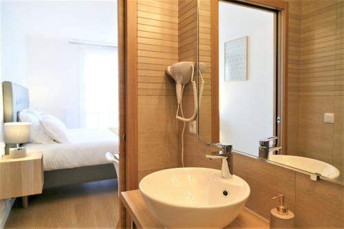 a bathroom with a sink and a mirror and a bed at Beausoleil Studio Metro Paris Sud in Le Kremlin-Bicêtre