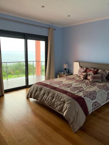 a bedroom with a large bed and a large window at The Right Place to Relax in Santo António