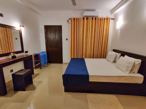 a bedroom with a bed and a mirror and a window at Sigiri Shen Residence in Sigiriya