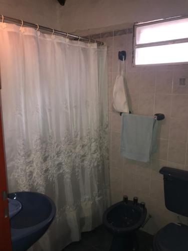 a bathroom with a toilet and a shower curtain at Las Azaleas Yala in Yala